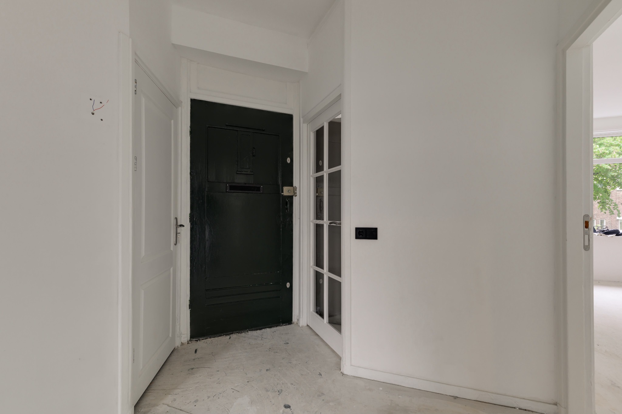 Afgewerkte entree van de woning met lichte wanden, binnendeuren en zicht op de voordeur.