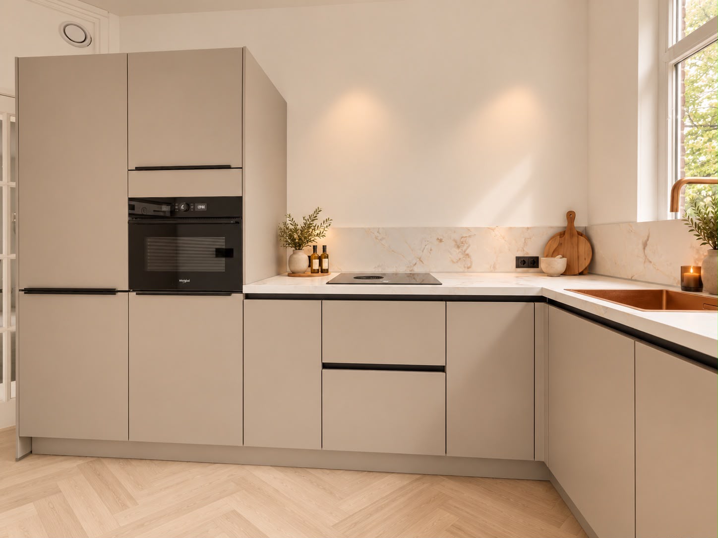 Lichte hoekkeuken in de gerenoveerde woning in Den Haag, met beige kasten, ingebouwde oven en werkblad onder het raam.