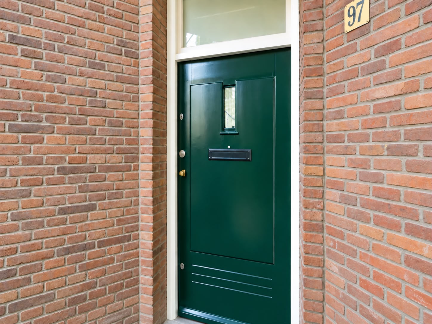 Groene voordeur van de gerenoveerde woning in Den Haag, gezien vanaf de straat.